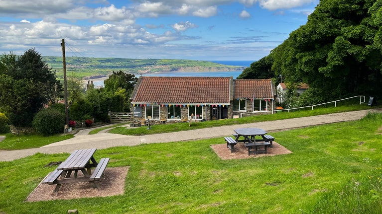 Ravenscar Visitor Centre in late spring with Robin Hood's Bay in background